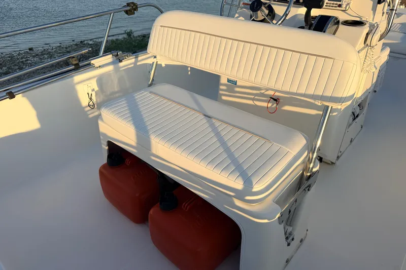 Slide: The Image of 2010 Boston Whaler 170 Montauk boat interior with cushioned seating and fuel tanks. - 41