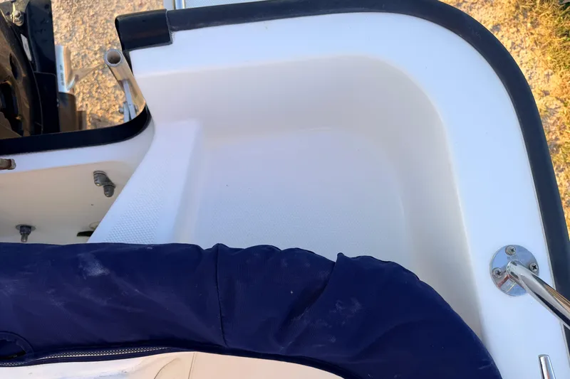 Slide: The Image of Interior view of a 2010 Boston Whaler 170 Montauk boat, featuring seating and hardware. - 51