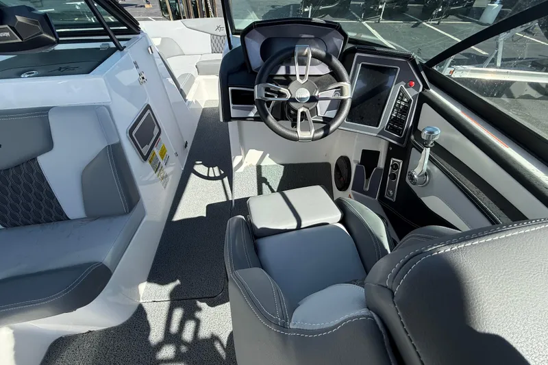 Slide: The Image of Interior of 2023 MasterCraft XT22 boat with modern steering and dashboard controls. - 6