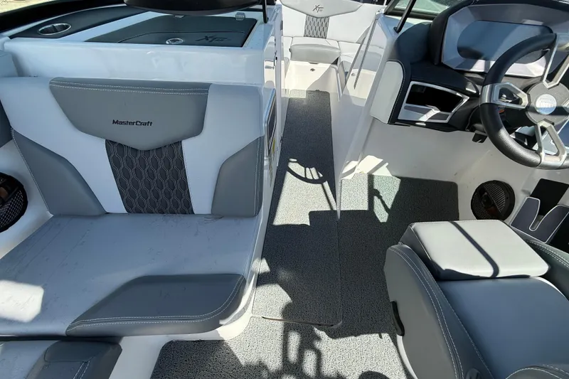 Slide: The Image of 2023 MasterCraft XT22 boat interior with gray seating and modern dashboard. - 8