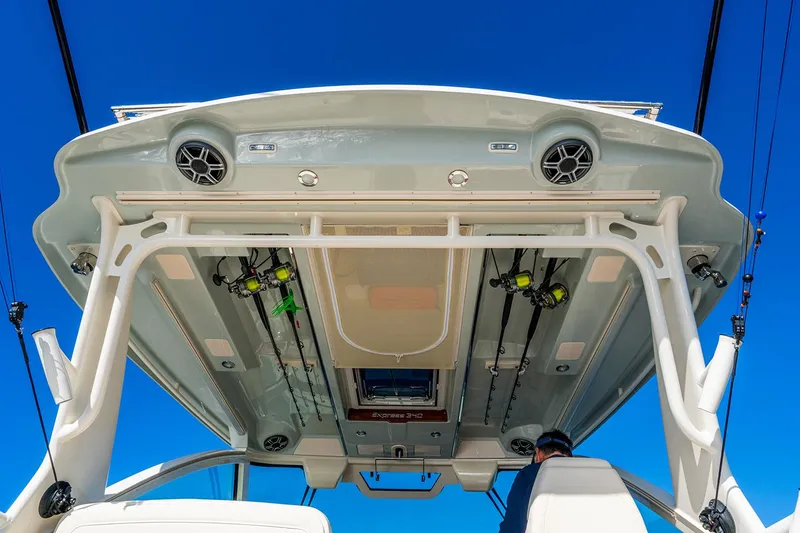 Slide: The Image of Manufacturer Provided Image: 2026 Grady-White Express 340 boat roof with fishing gear and speakers against blue sky. - 15