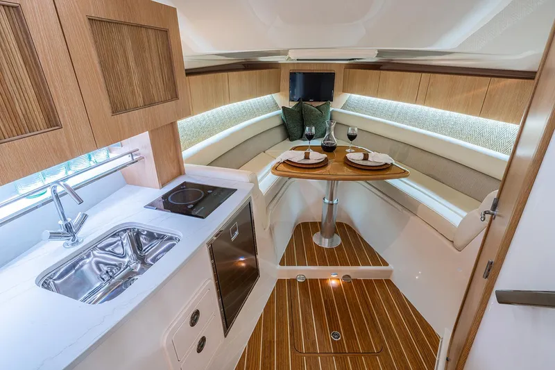 Slide: The Image of Manufacturer Provided Image: Luxurious interior of 2026 Grady-White Express 340 yacht with kitchenette and dining area. - 17