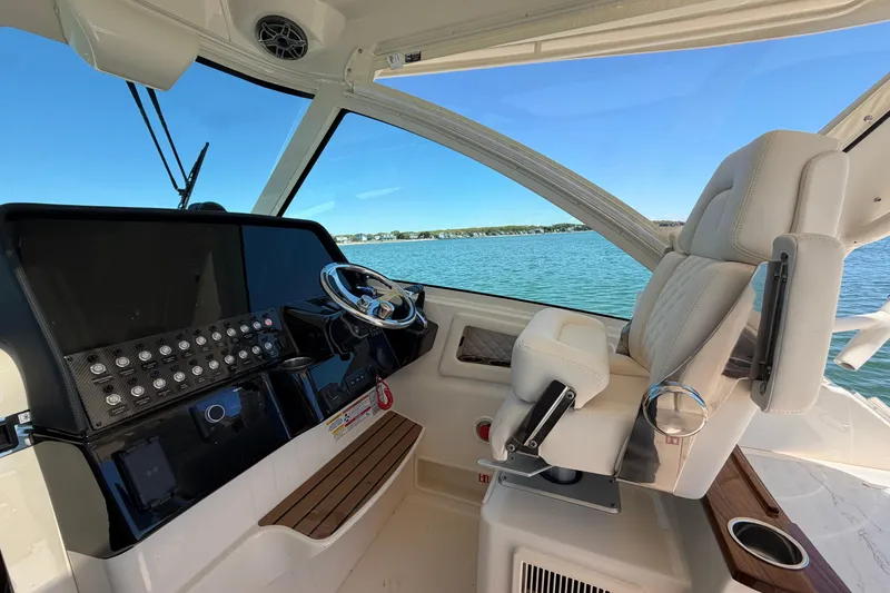 Slide: The Image of Helm of 2026 Grady-White Express 340 boat with luxurious seating and control panel. - 21