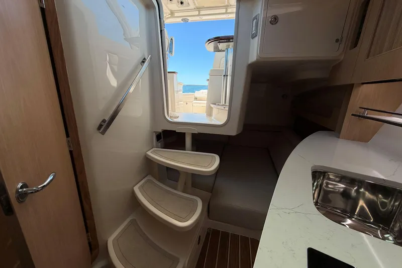 Slide: The Image of Interior of 2026 Grady-White Express 340 boat, featuring stairs and compact cabin space. - 28