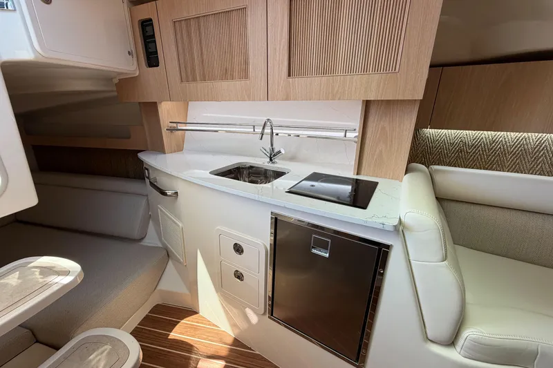 Slide: The Image of Interior of 2026 Grady-White Express 340 boat, featuring a compact kitchen with sink and stove. - 30