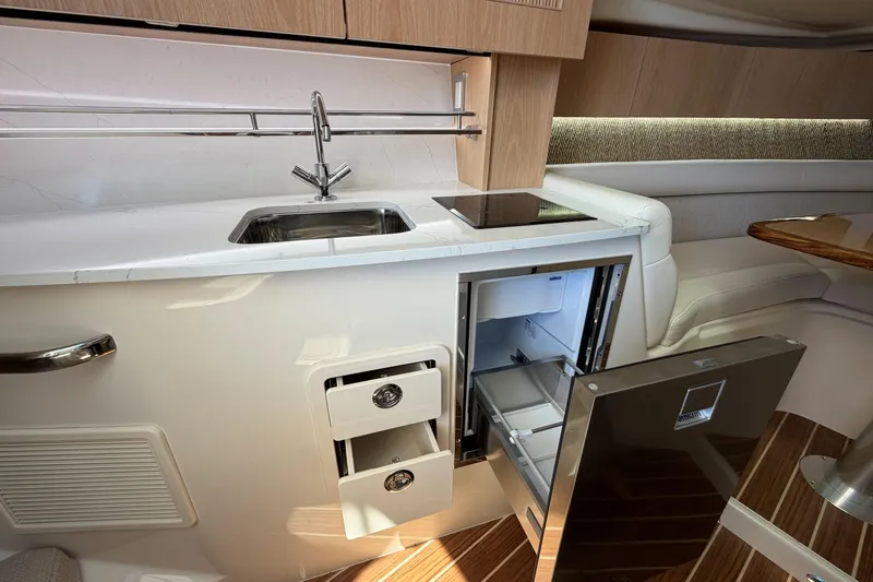Slide: The Image of 2026 Grady-White Express 340 interior kitchen with sink, stove, and open refrigerator. - 31
