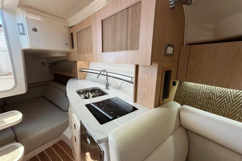 Slide: The Image of 2026 Grady-White Express 340 interior with modern kitchenette and seating area. - 32