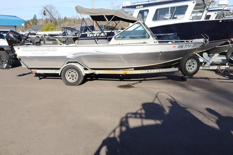 The Image of 2000 Alumaweld Intruder Outboard 20 boat on trailer, parked outdoors. - 1