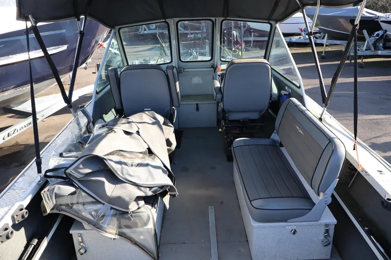 Slide: The Image of 2000 Alumaweld Intruder Outboard 20 interior with seating and canopy, parked on trailer. - 3
