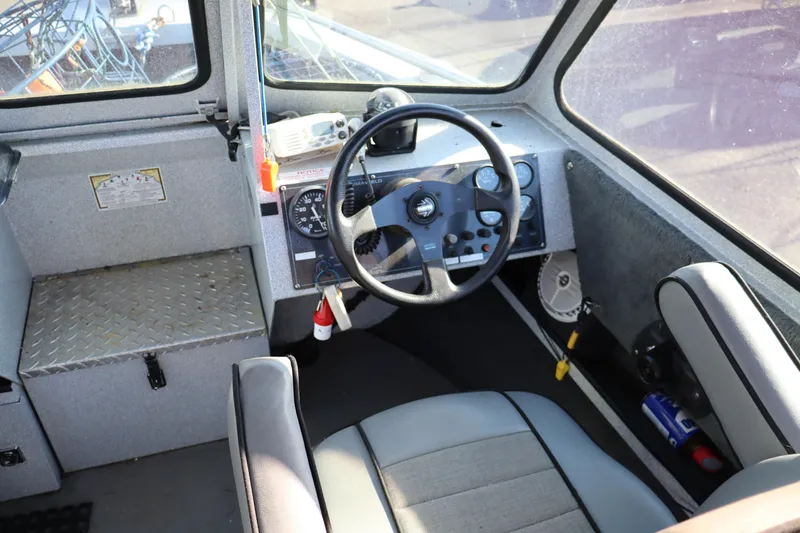 Slide: The Image of Interior of 2000 Alumaweld Intruder Outboard 20 boat, featuring steering wheel and control panel. - 4