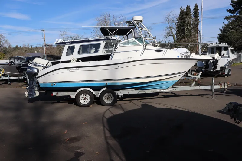 The Image of 2000 Seaswirl Striper 2300 Walkaround O/B boat on trailer, parked outdoors. - 1