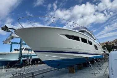 Slide: The Image of 2013 Prestige 550 yacht on dry dock under a partly cloudy sky. - 2