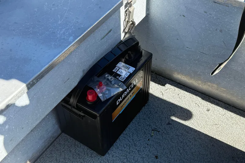 Slide: The Image of Battery inside 1983 Alumaweld Center Console boat, placed on metal floor. - 14