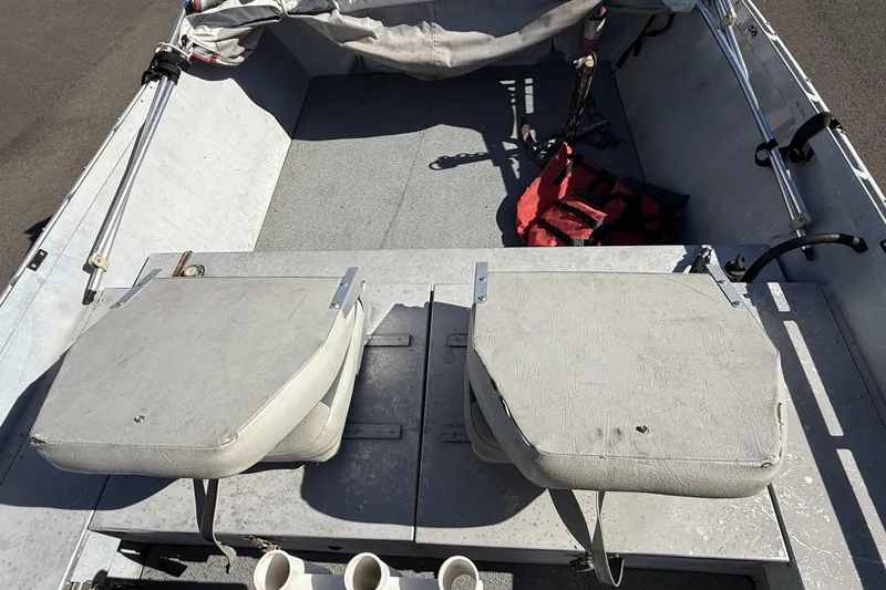 Slide: The Image of 1983 Alumaweld Center Console boat interior with seats and fishing gear. - 16
