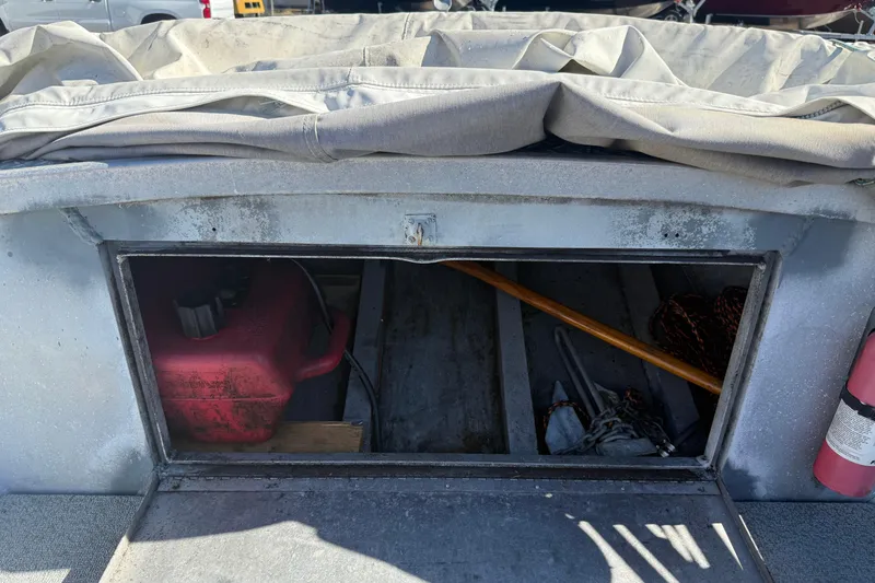 Slide: The Image of 1983 Alumaweld Center Console storage compartment with red fuel tank and equipment. - 18