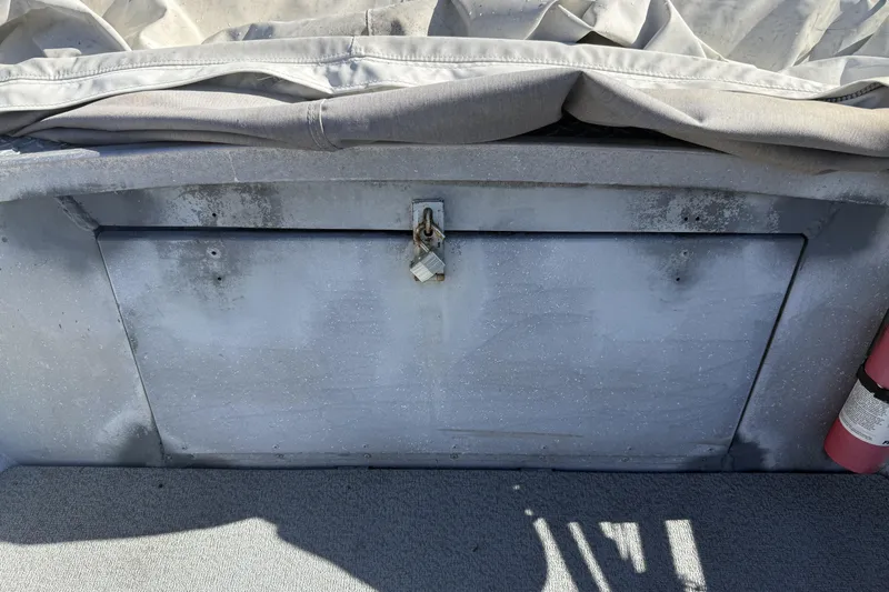 Slide: The Image of 1983 Alumaweld Center Console boat storage compartment with padlock and fire extinguisher. - 19