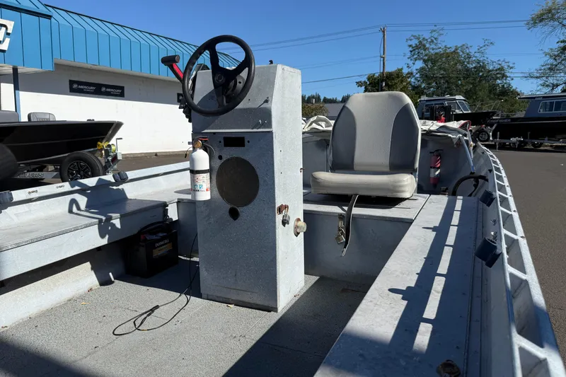 Slide: The Image of 1983 Alumaweld Center Console boat with steering wheel and seat, parked outdoors. - 21