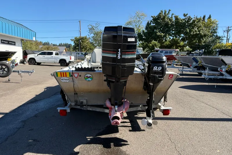 Slide: The Image of 1983 Alumaweld Center Console boat with dual outboard motors in a parking lot. - 4