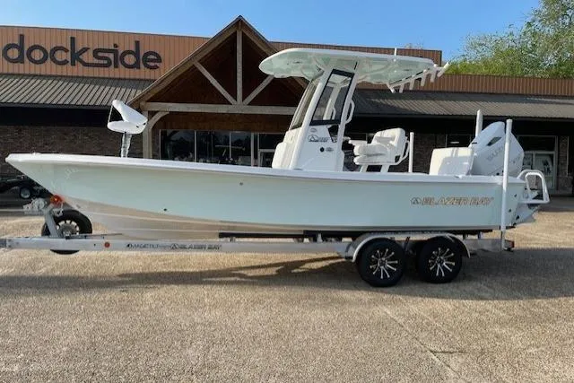 Slide: The Image of 2026 Blazer Bay 2440 boat on trailer outside Dockside store. - 13