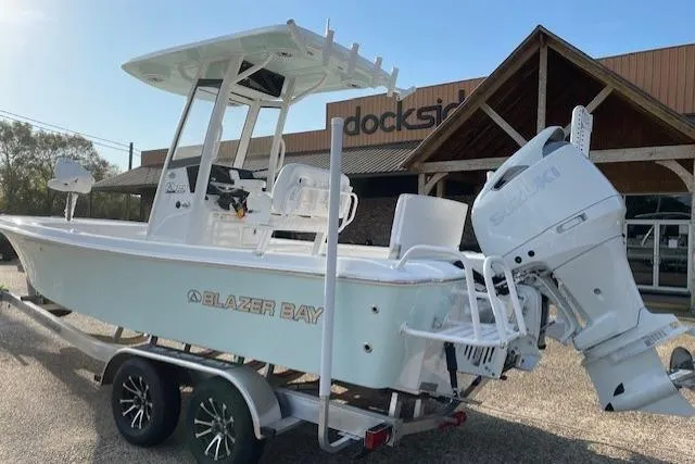 Slide: The Image of 2026 Blazer Bay 2440 boat on trailer, parked outside a building. - 14