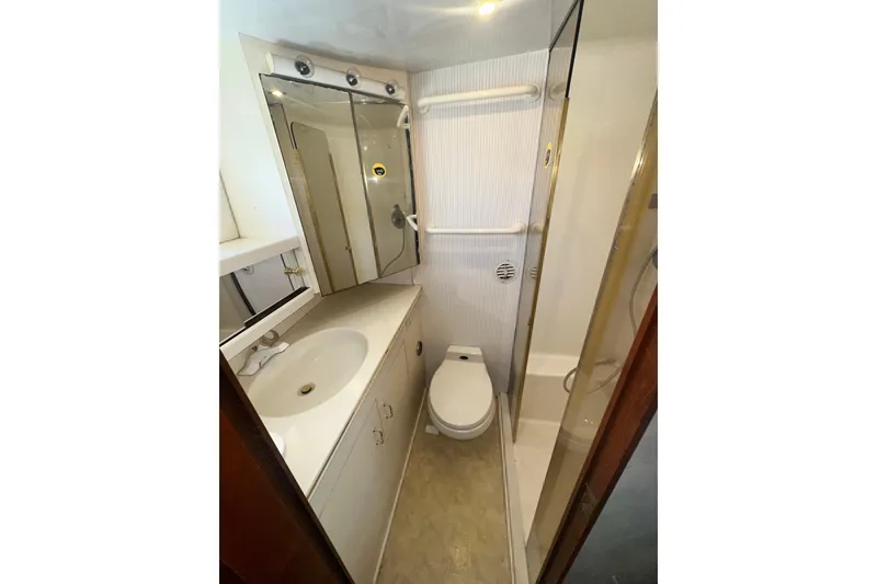 Slide: The Image of Compact yacht bathroom with shower, sink, and toilet on a 1994 Oceans motor yacht. - 12