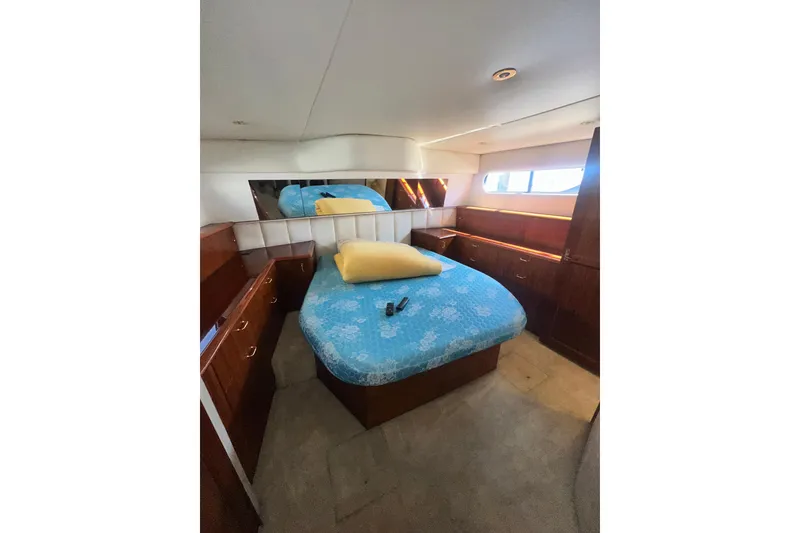 Slide: The Image of Luxurious 1994 Oceans motor yacht bedroom with blue bedding and wooden cabinetry. - 14