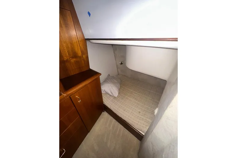 Slide: The Image of 1994 Oceans motor yacht cabin with wooden cabinetry and cozy sleeping area. - 15