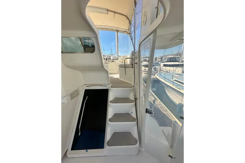 Slide: The Image of Interior view of a 1994 Oceans motor yacht, featuring stairs and marina backdrop. - 26