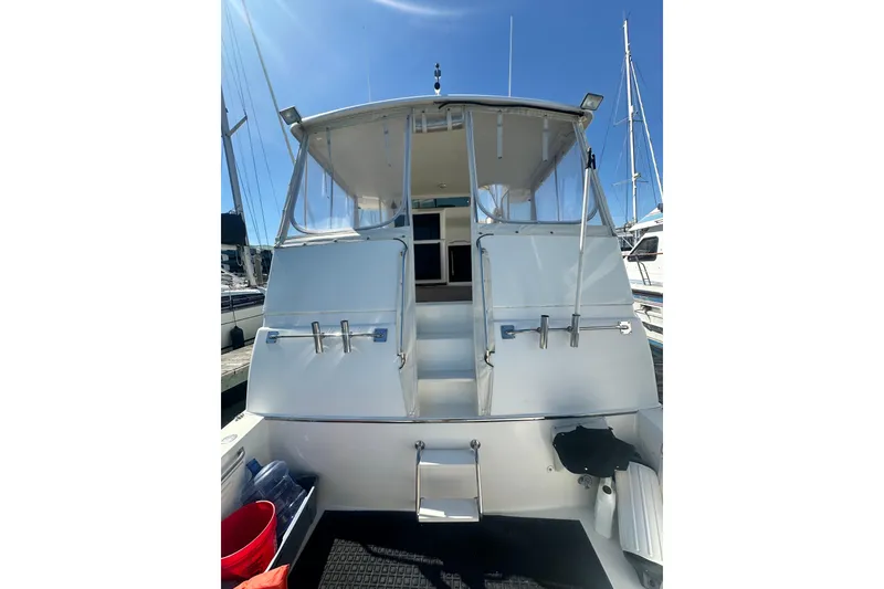 Slide: The Image of 1994 Oceans motor yacht with enclosed cockpit, docked under clear blue sky. - 28