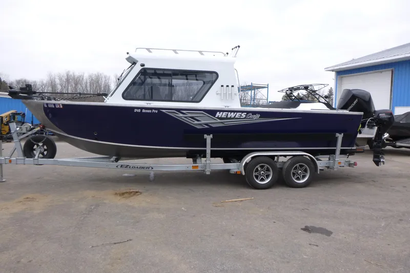 Slide: The Image of 2025 Hewescraft 240 Ocean Pro boat on trailer, parked outdoors. - 4