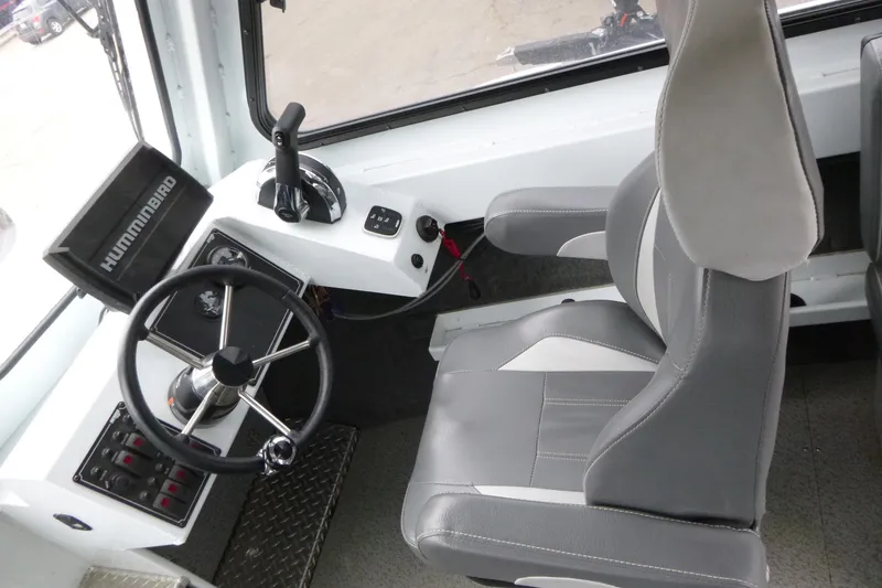 Slide: The Image of Interior of 2025 Hewescraft 240 Ocean Pro boat with steering wheel and control panel. - 8
