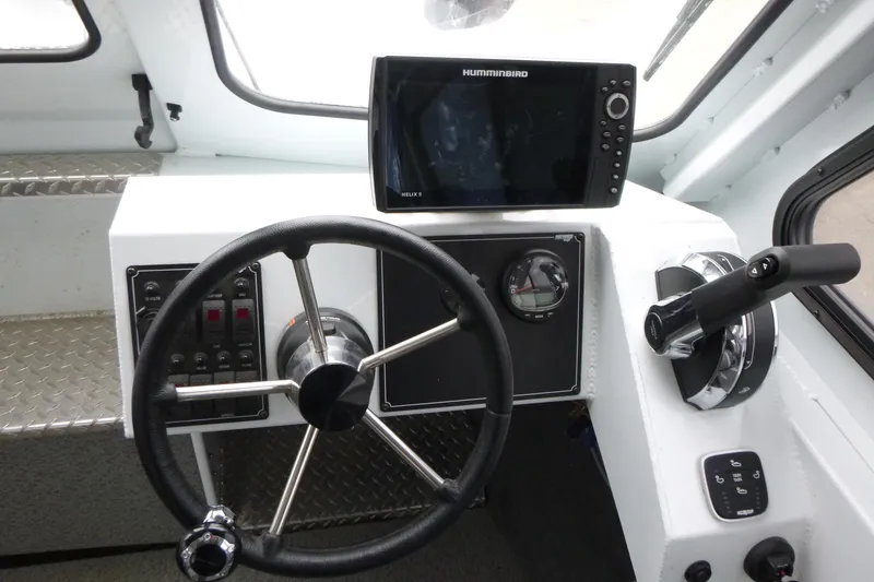 Slide: The Image of Helm of 2025 Hewescraft 240 Ocean Pro with steering wheel and navigation system. - 9