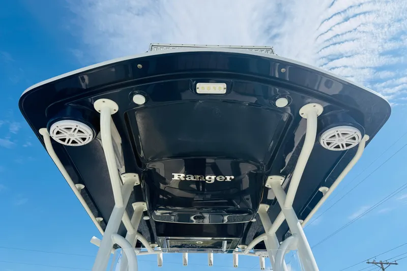 Slide: The Image of 2022 Ranger 2660 Bay boat, underside view with speakers, against a blue sky. - 13