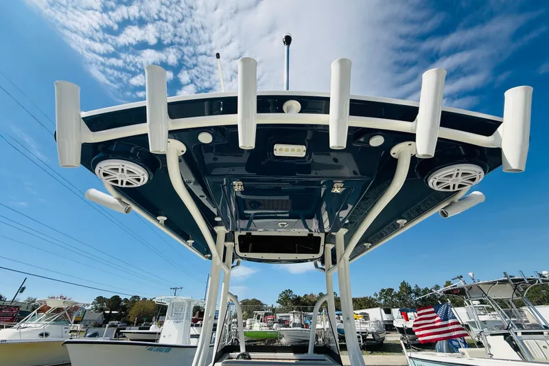 Slide: The Image of 2022 Ranger 2660 Bay boat with rod holders and speakers under a clear sky. - 15