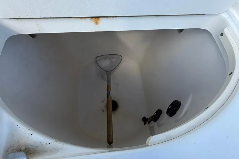 Slide: The Image of Storage compartment of a 2007 Boston Whaler 320 Outrage Cuddy Cabin with a net inside. - 18