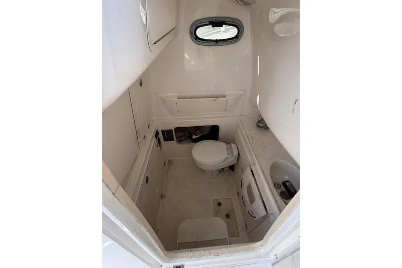 Slide: The Image of 2007 Boston Whaler 320 Outrage Cuddy Cabin interior with toilet and porthole window. - 21