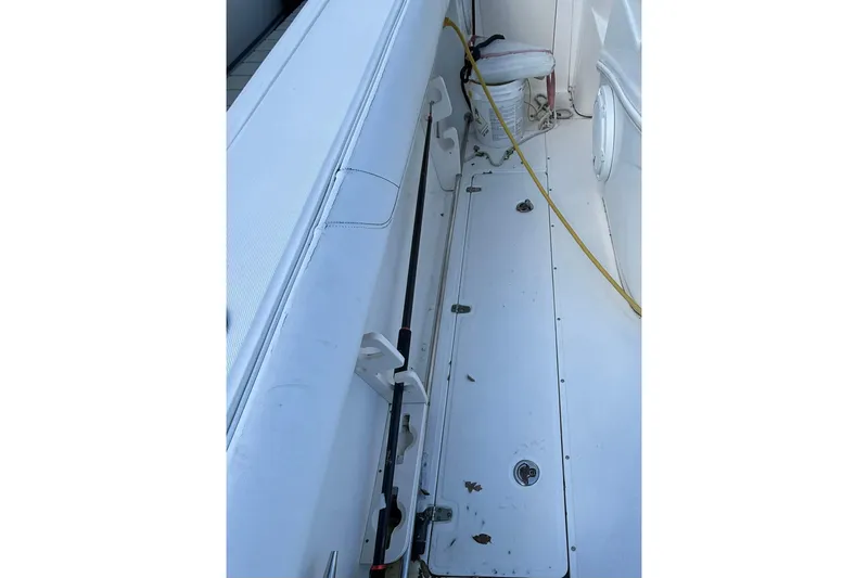 Slide: The Image of 2007 Boston Whaler 320 Outrage Cuddy Cabin deck with fishing rod holder and storage compartment. - 27