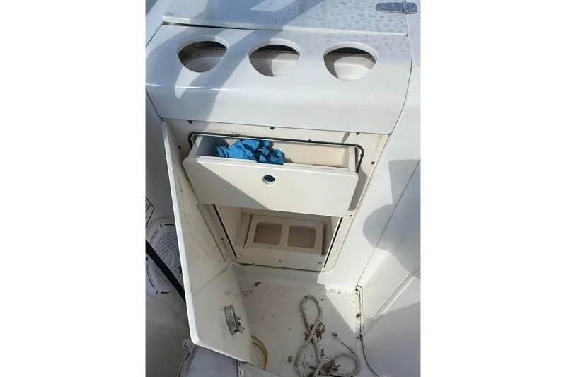 Slide: The Image of 2007 Boston Whaler 320 Outrage Cuddy Cabin interior storage compartment with ropes and gloves. - 31