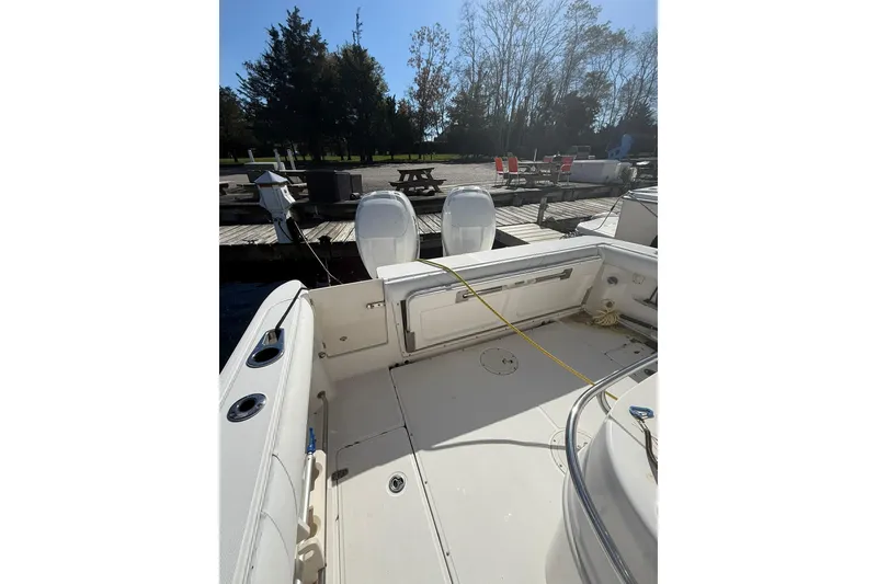 Slide: The Image of 2007 Boston Whaler 320 Outrage Cuddy Cabin docked, showcasing spacious deck and twin engines. - 7