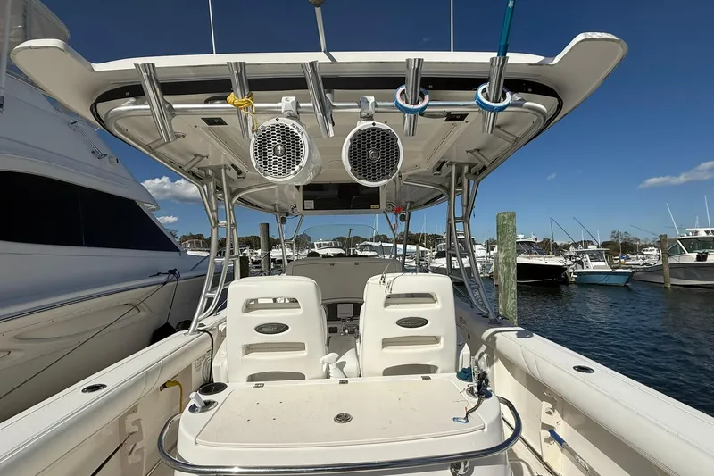 Slide: The Image of 2007 Boston Whaler 320 Outrage Cuddy Cabin at marina, showcasing seating and overhead speakers. - 8