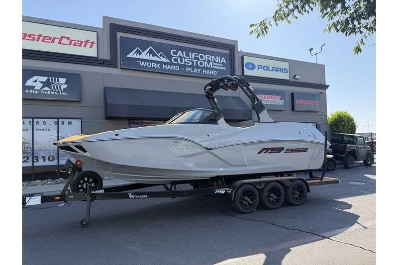 The Image of 2025 MB B52 25 Alpha boat on trailer outside California Custom showroom. - 1