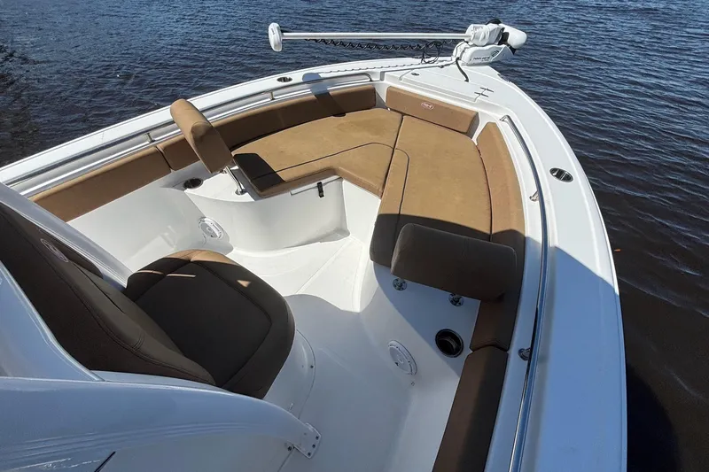 Slide: The Image of 2022 Sea Hunt Ultra 229 boat with tan seating, on calm water. - 12