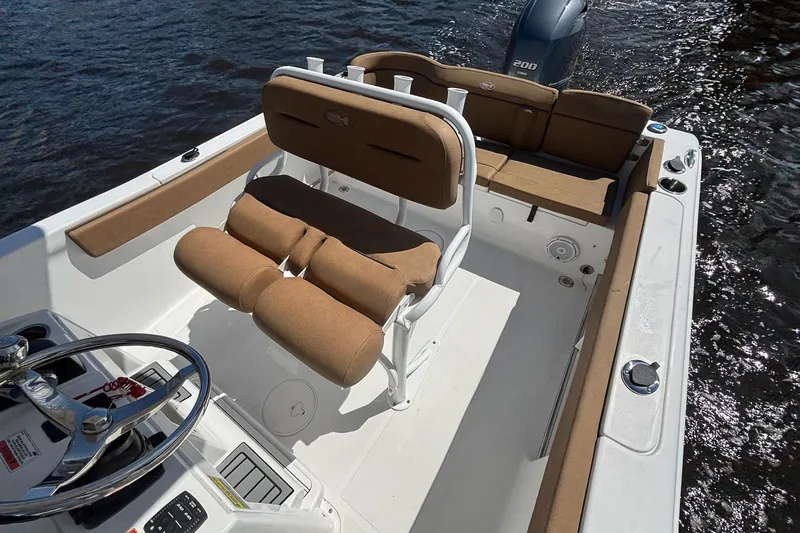 Slide: The Image of 2022 Sea Hunt Ultra 229 boat interior with tan seating and steering wheel. - 15