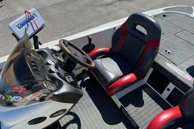 Slide: The Image of 2004 Triton Tr-186 SC boat interior with steering wheel and red-accented seat. - 10