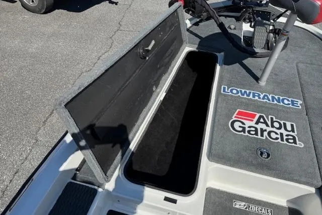 Slide: The Image of 2004 Triton Tr-186 SC boat deck with storage compartment and fishing gear logos. - 15