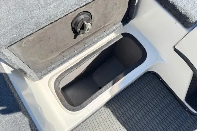 Slide: The Image of Storage compartment in 2004 Triton Tr-186 SC boat, featuring secure latch and carpeted interior. - 18