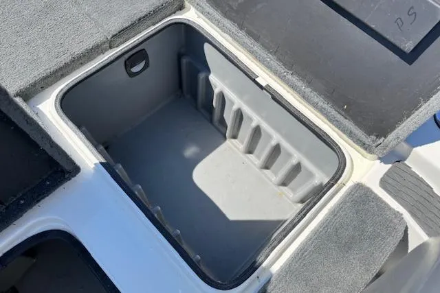 Slide: The Image of Open storage compartment on a 2004 Triton Tr-186 SC boat, featuring gray interior. - 23