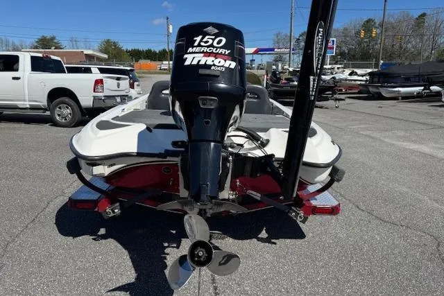 Slide: The Image of 2004 Triton Tr-186 SC boat with Mercury 150 engine in a parking lot. - 5