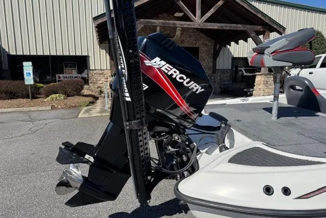 Slide: The Image of 2004 Triton Tr-186 SC boat with Mercury outboard motor, parked near a building. - 6