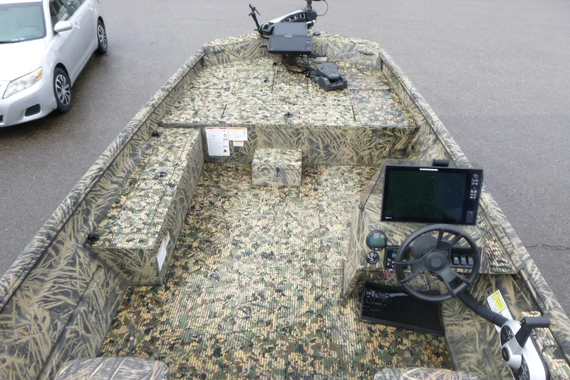 Slide: The Image of 2024 Lowe Roughneck 2070 boat interior with camouflage design and advanced navigation equipment. - 18
